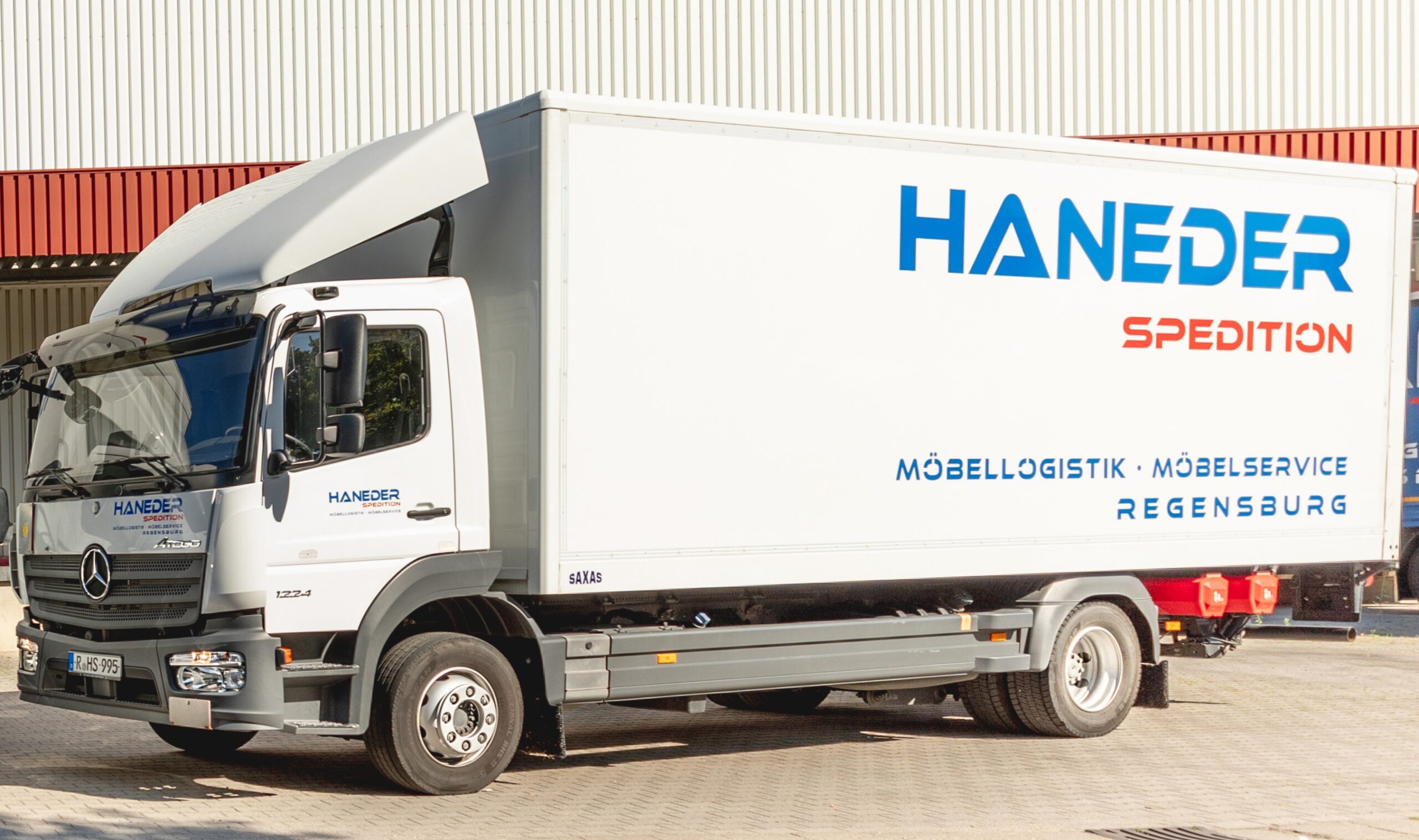 Haneder LKW steht vor einer Lagerhalle